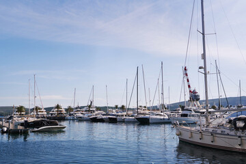 Sailing yachts moored on the pier against the background of a clear sky