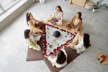 Group of young girls meditating during women circle training, top view