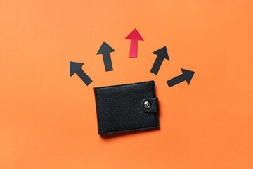 Wallet with many arrows on orange background. Concept of rising price