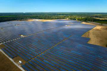 Aerial view of big sustainable electric power plant with many rows of solar photovoltaic panels for...