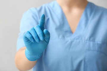 Female doctor using virtual screen on light background, closeup