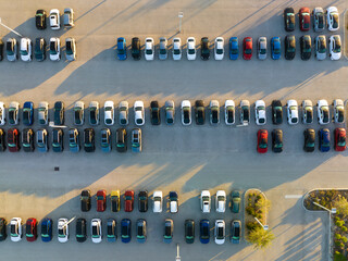 Large parking lot of local dealer with many brand new cars parked for sale. Development of american...