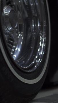 Extra close-up of a wheel of a classic car and a camera flight along the body. Footage. Lots of chrome parts, lowered suspension, youth style