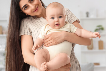 Happy mother holding her little baby at home, closeup