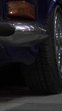 Extra close-up of a wheel of a classic car and a camera flight along the body. Footage. Lots of chrome parts, lowered suspension, youth style
