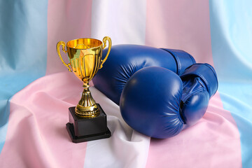 Gold cup and boxing gloves on transgender flag