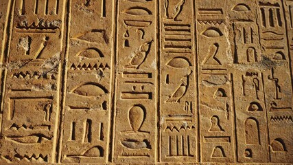 Ancient Hieroglyphs Carved in Sandstone: Vertical Rows of Ancient Symbols and Carvings on Weathered Wall - Powered by Adobe