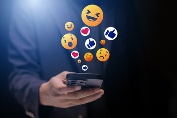 Close-up of man's hand using smartphone to play social media with emoticons or notifications popup.	
