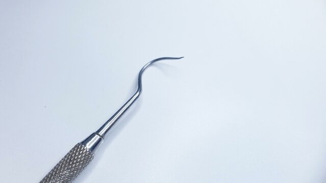 Close-up of a dental scaler tool on a white background. Ideal for medical, dental, or healthcare related projects.