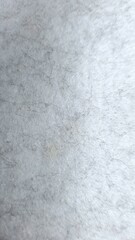 Abstract image of light gray textured surface with scattered dark hairs. Ideal for backgrounds, textures, and artistic projects.