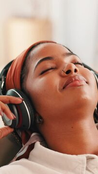 Home, relax and woman with headphones, music and listening to playlist in living room, smile or break. Streaming, song and black person with tech for audio, resting or entertainment for girl in house