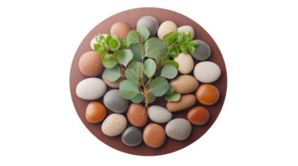 Assorted natural stones and green leaves arranged aesthetically on round wooden surface in harmonious display