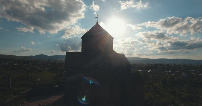 Ascending drone shot of Kotavank church in Nerkin Getashen village in Gegharkunik, Armenia at sunset