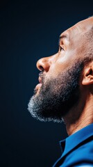 Obraz premium Resilient Leadership Profile Cinematic Closeup of Professional Black Male Executive in Vibrant Blue - Authentic Workplace Diversity and Empowerment Imagery