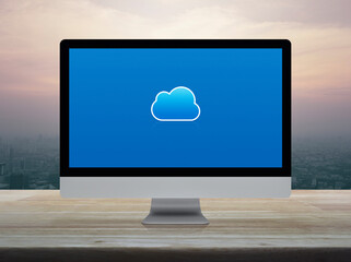 Cloud computing icon on modern computer monitor screen on wooden table over city tower and skyscraper at sunset sky, vintage style, Technology cloud computing concept