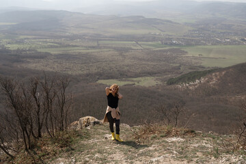 Hiker Mountain Vista. Woman hikes on mountain edge, vista opens on a sunny day for outdoor...