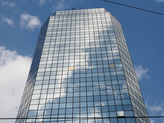 Modern Glass Skyscraper with Blue Sky Reflection Photographed from Low Angle