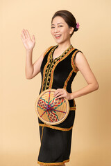 Beautiful Female Kadazandusun Native in traditional costume posing in plain background