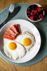 Breakfast. Fried eggs with salmon slices and berries