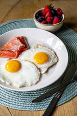 Breakfast. Fried eggs with salmon slices and berries