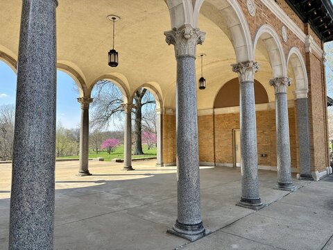 Granite columns and arched portico overlook blooming spring parkland