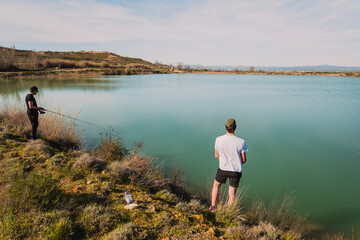 Two Men Fishing on a Sunny Day by the Lake