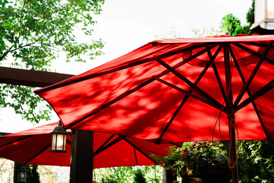 Bright red umbrellas provide shade in outdoor cafe setting