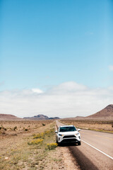 White SUV parked on roadside in vast West Texas desert landscape