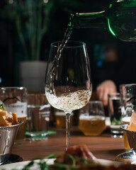 glass of wine being poured into a wine glass in restaurant