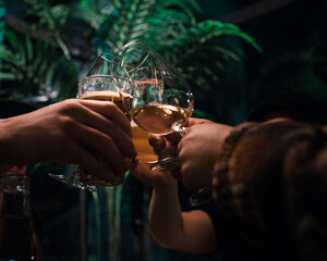 peoples hands cheers drinks in the middle of a restaurant