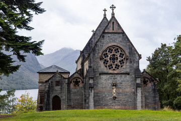Fototapeta premium St Mary and St Finnan Church rises above the shores of Loch Shiel, near the Glenfinnan Viaduct. A Gothic gem nestled in the wild landscape of the Scottish Highlands.​