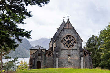 Fototapeta premium St Mary and St Finnan Church rises above the shores of Loch Shiel, near the Glenfinnan Viaduct. A Gothic gem nestled in the wild landscape of the Scottish Highlands.​