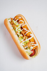 A delicious hot dog features crispy toppings and fresh veggies, served at a lively food event