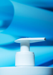 Liquid soap dispenser close-up on a blue background. Liquid dispenser. Background for purity. Hygiene and science.