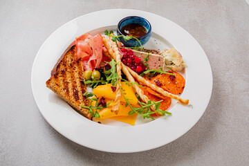 A gourmet platter features a tasty mix of meats, cheeses, and vibrant garnishes for gatherings