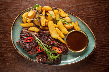 Grilled steak, crispy potato wedges, and a tasty dip create a gourmet delight
