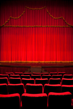 Empty Theater Seats Facing Red Velvet Stage Curtain