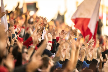 Fans cheering with raised hands in sports stadium