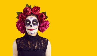 Joyful dreamy woman in Halloween costume thinks and imagines something pleasant on orange...