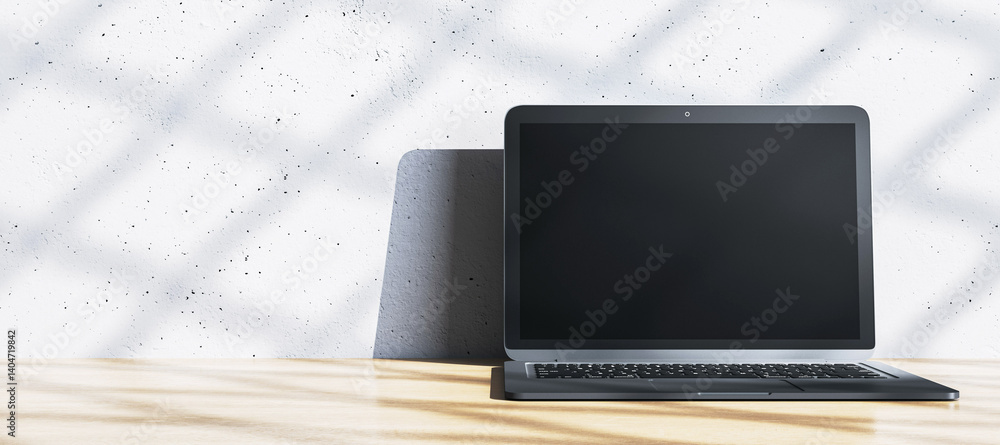Poster modern laptop on wooden desk against white interior wall with shadow patterns in clean contemporary 