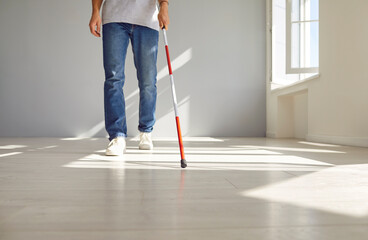 Deaf visually impaired man uses a stick to walk. Crop low section view blind man with hearing loss...