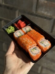  a chef in a restaurant prepares delicious Japanese sushi and rolls