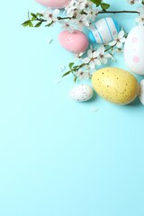 Happy Easter. Colorful eggs and white spring flowers on color background, space for text or advertising