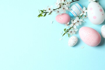 Happy Easter. Colorful eggs and white spring flowers on color background, space for text or advertising