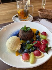 Chocolate fondant on a plate with berries, ice cream and mousse