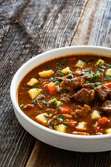 Beef vegetables goulash soup on wooden table