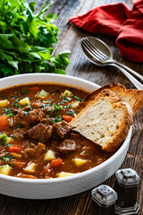 Beef vegetables goulash soup on wooden table