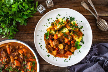 Beef vegetables goulash with potatoes on wooden table