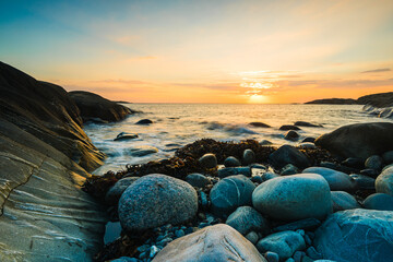 Coastal sunset over Lerkil Sweden with rocks and soft waves at twilight