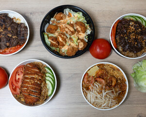 Overhead view of various food bowls with meat and vegetable toppings